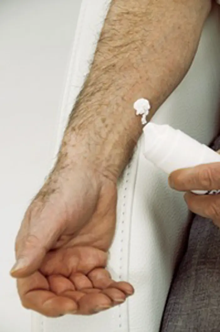 Man applying a skin cream containing <a tabindex='0' class='popover-dismiss' href='/hormones/testosterone/' data-target-type='infoSheet' data-target-url='/hormones/testosterone/' data-bs-toggle='popover' data-bs-trigger='focus' title='testosterone' data-bs-content='1429' >testosterone</a> used to replace this sex hormone in men who have lost their sex drive, or had their <a tabindex='0' class='popover-dismiss' href='/glands/testes/' data-target-type='infoSheet' data-target-url='/glands/testes/' data-bs-toggle='popover' data-bs-trigger='focus' title='testes' data-bs-content='1454' >testes</a> removed due to cancer or other diseases.